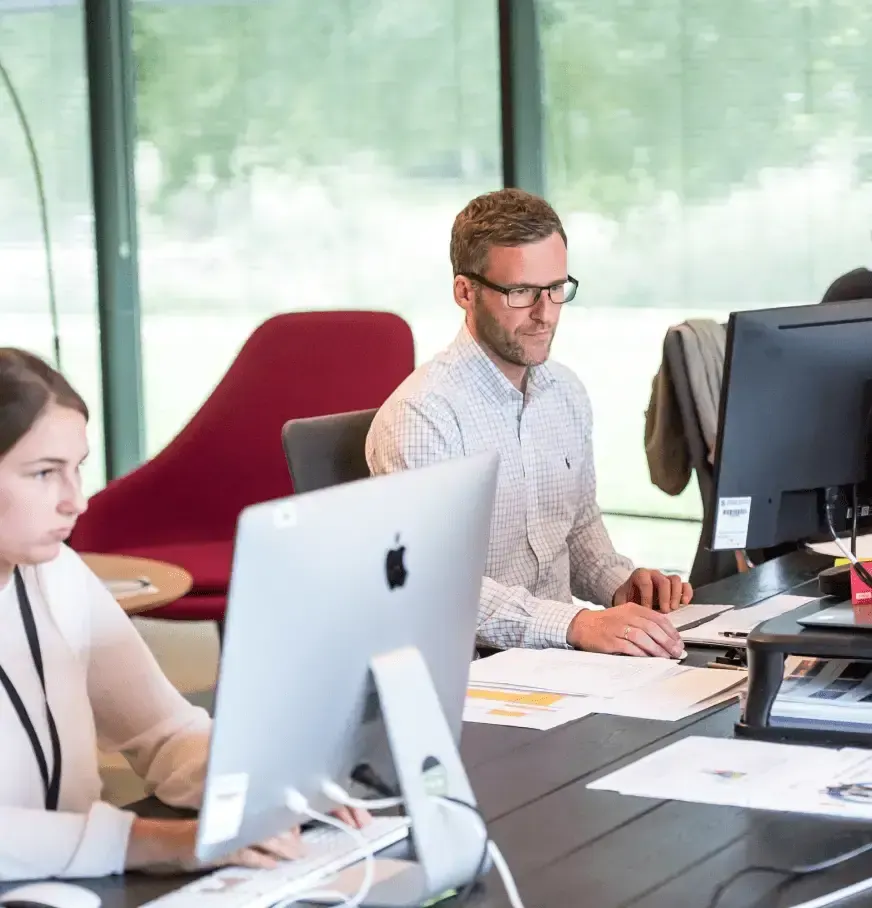 Équipe au travail sur des ordinateurs dans un open space
